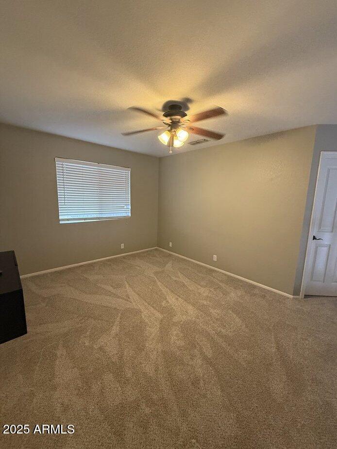 6079 West Irma Lane Glendale, AZ 85308 - Photo 14 of 33 an empty room with windows and chandelier fan