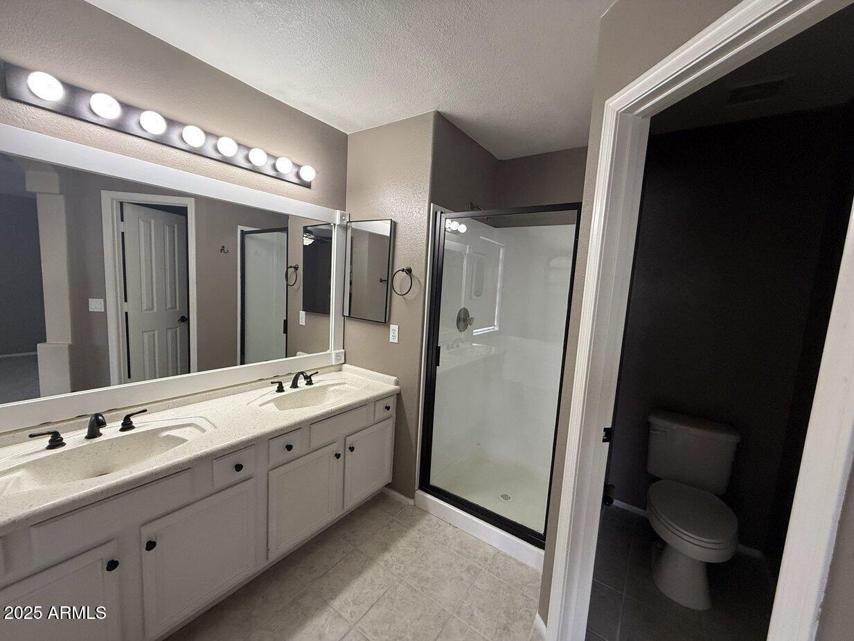 6079 West Irma Lane Glendale, AZ 85308 - Photo 17 of 33 a bathroom with a double vanity sink toilet and shower