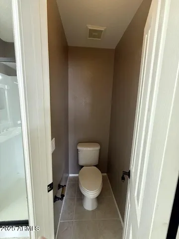 a white toilet sitting in a bathroom next to a sink