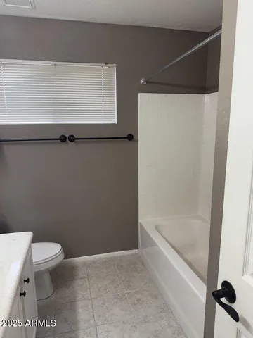 a bathroom with a granite countertop sink a toilet and a bathtub