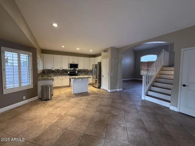 a kitchen with a refrigerator and white cabinets
