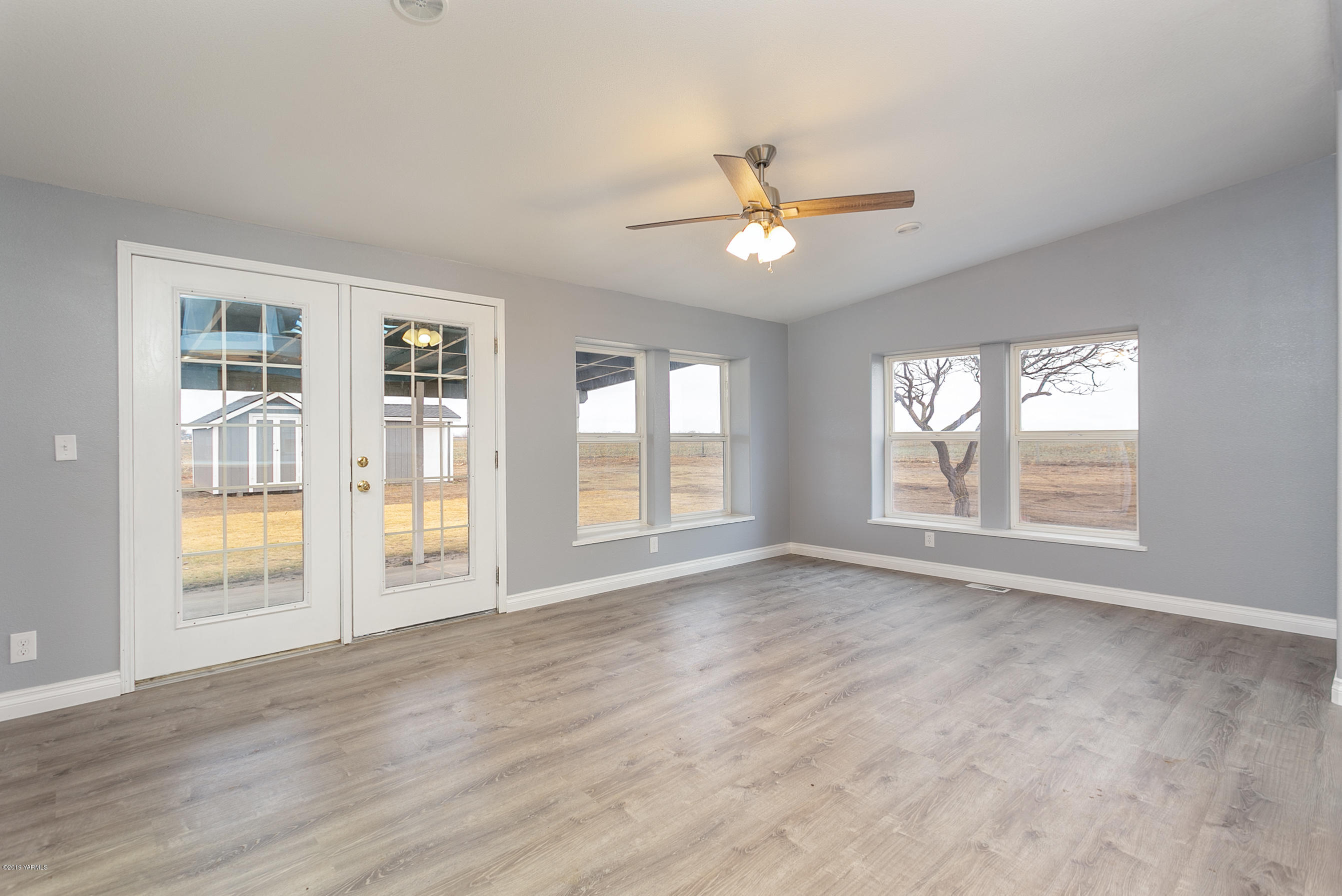 1361 Highschool Road Mabton, WA 98935 - Photo 3 of 24 a view of an empty room with a window and wooden floor