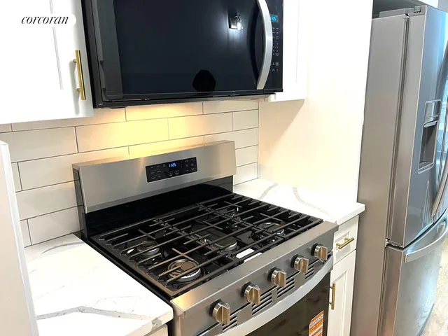a stove top oven sitting inside of a kitchen
