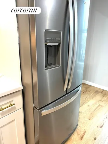 a view of a refrigerator in kitchen and wooden floor