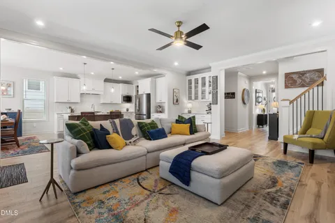 a living room with furniture kitchen view and a chandelier