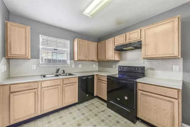 a kitchen with a stove sink and cabinets