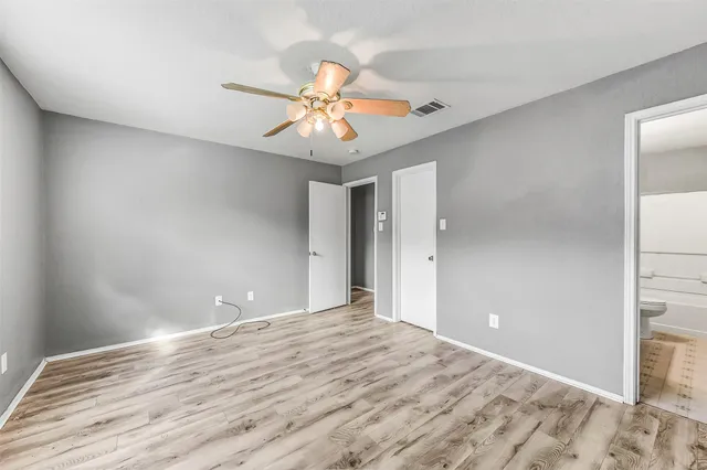 a view of an empty room with a chandelier fan