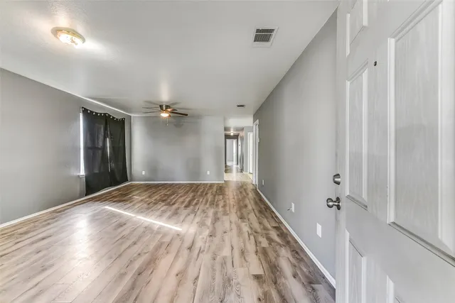 a view of empty room with wooden floor
