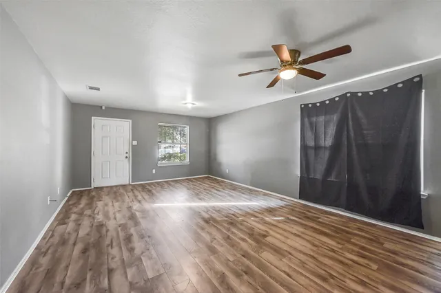 a view of empty room with wooden floor
