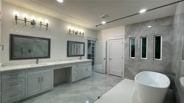 a spacious bathroom with a double vanity sink a large mirror and a bathtub