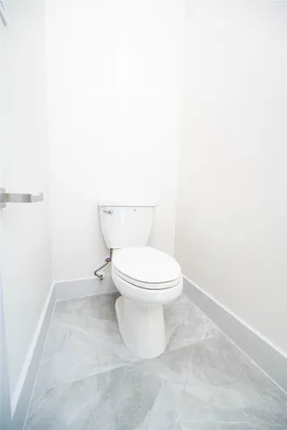 a white toilet sitting next to a white cabinet