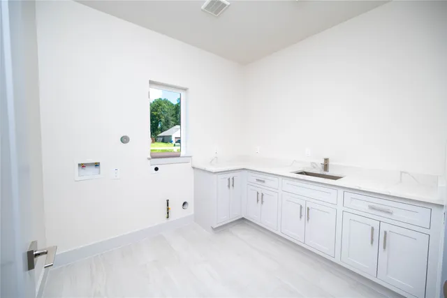 a hallway with white cabinets and window