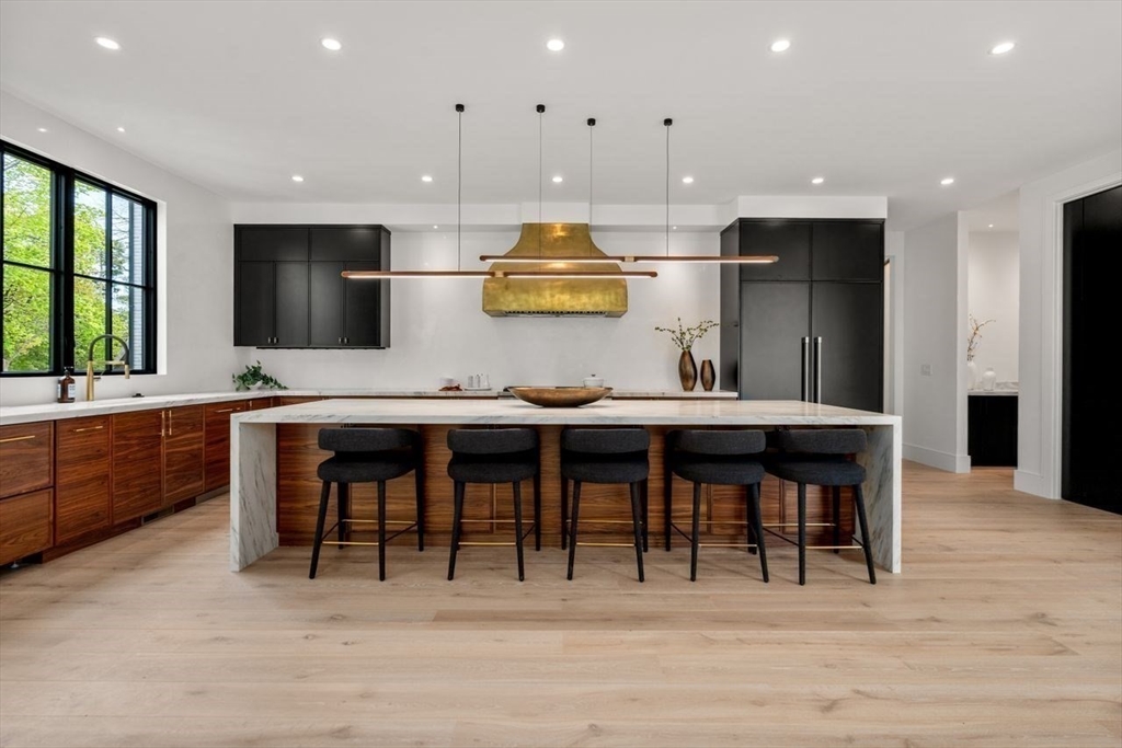 279 Fuller Street Newton, MA 02465 - Photo 17 of 42 a kitchen with stainless steel appliances kitchen island granite countertop a table chairs sink and cabinets