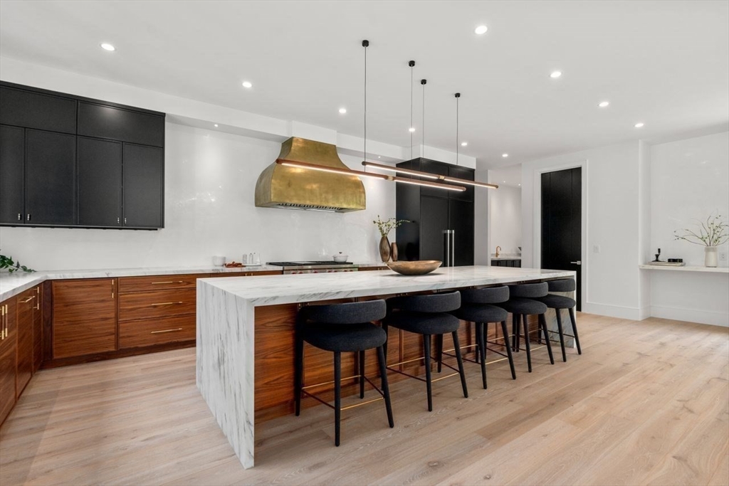 279 Fuller Street Newton, MA 02465 - Photo 18 of 42 a kitchen with stainless steel appliances granite countertop a kitchen island hardwood floor sink stove dining table and chairs
