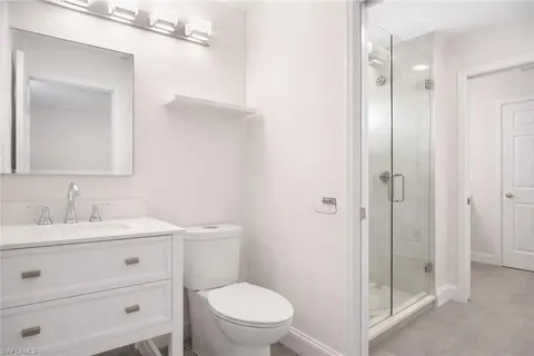 a bathroom with a toilet a sink a mirror and vanity