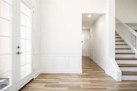 a view of a hallway with wooden floor and entryway
