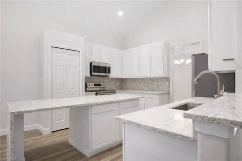 a kitchen with a sink a microwave and cabinets
