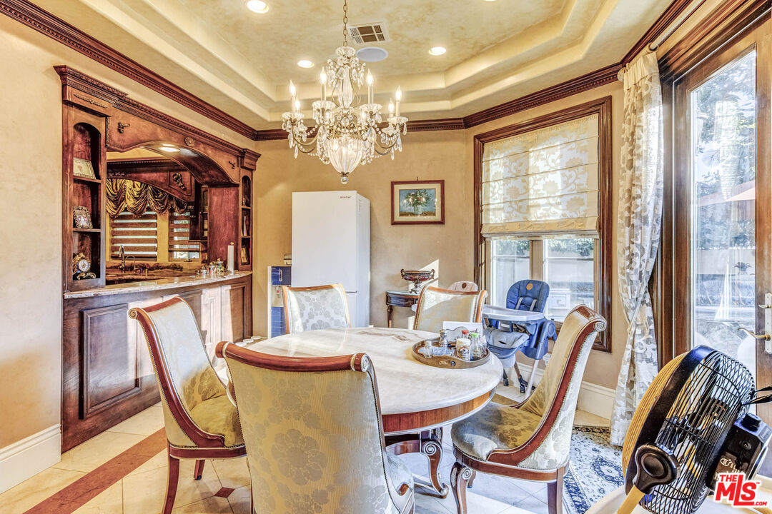 8336 Lexington Road Downey, CA 90241 - Photo 15 of 49 a view of a dining room with furniture a chandelier and large windows
