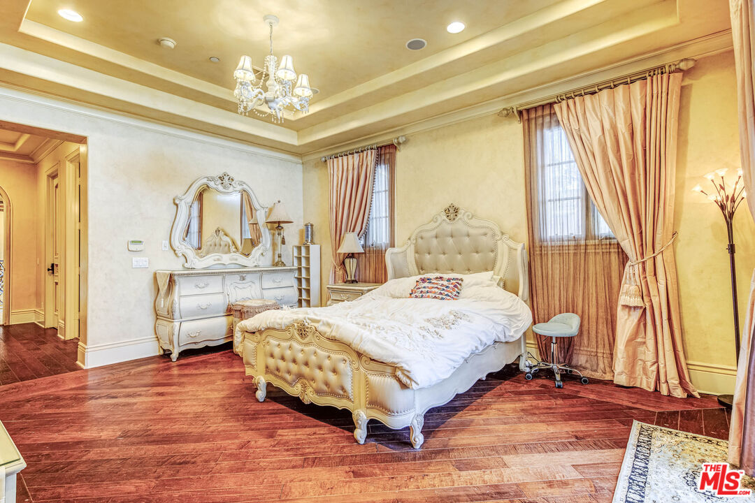8336 Lexington Road Downey, CA 90241 - Photo 31 of 49 a bedroom with a large bed and a chandelier