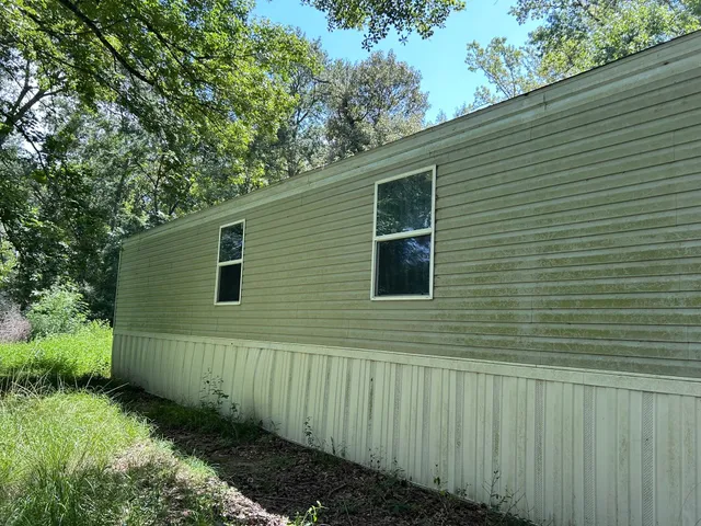 a front view of a house with a yard and tree s