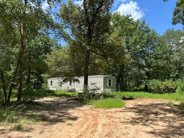 a front view of a house with a yard and tree s