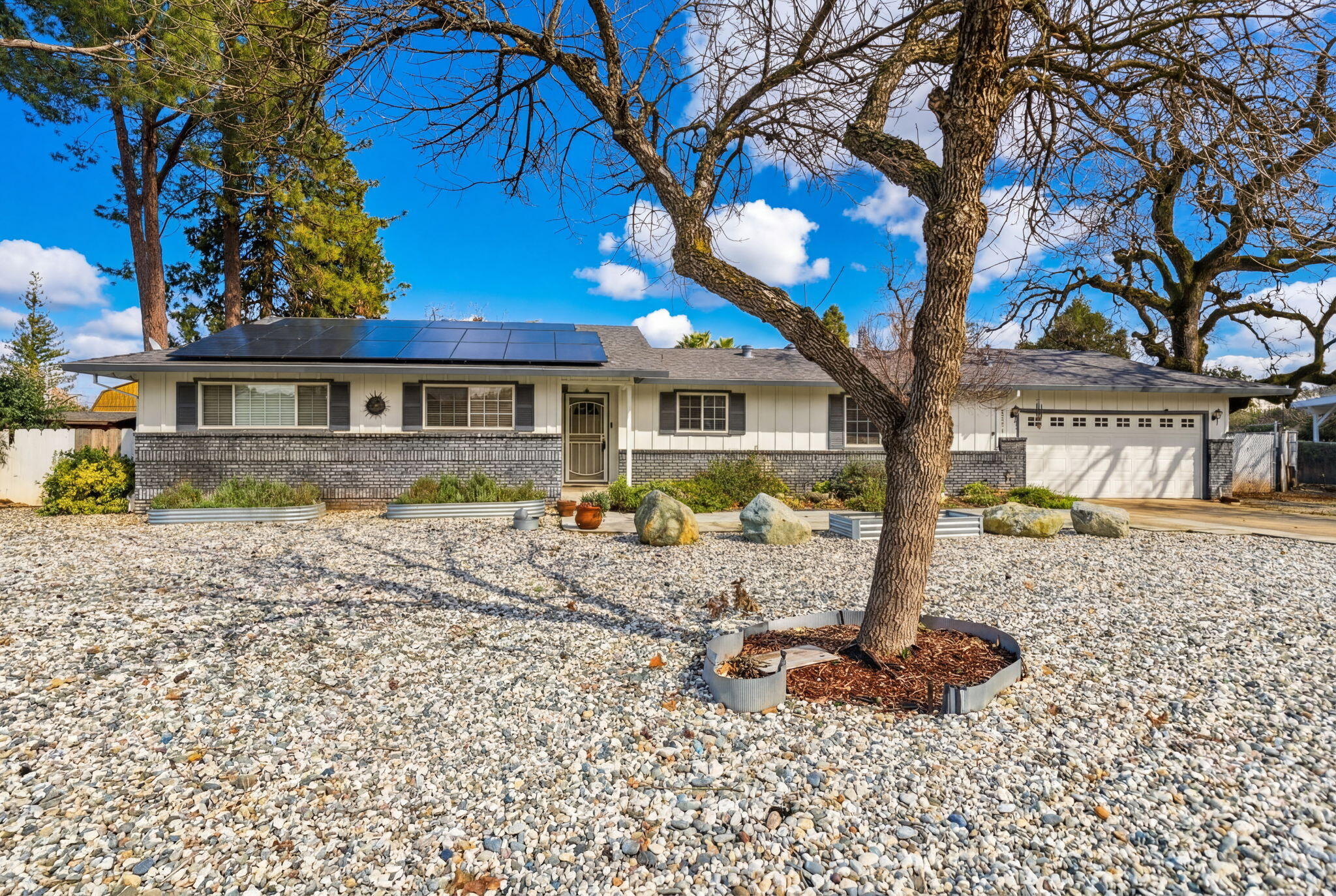 6927 Riata Drive Redding, CA 96002 - Photo 2 of 39 a front view of a house with garden