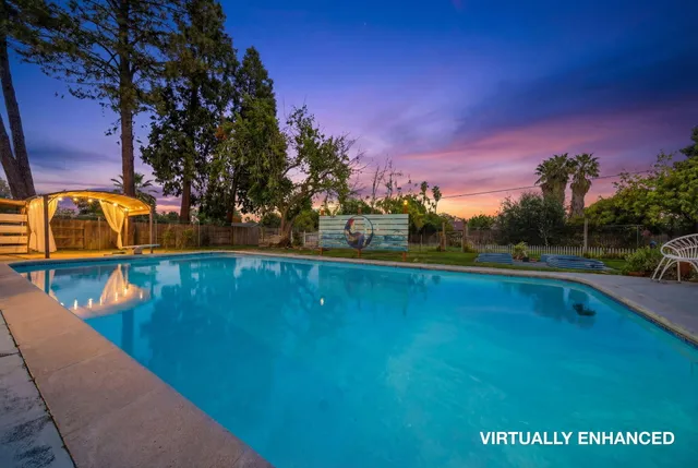 a view of a swimming pool with an outdoor seating and a garden