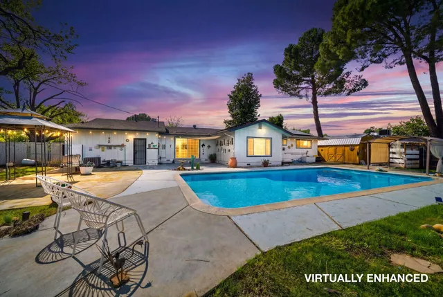 a view of a house with swimming pool and sitting area
