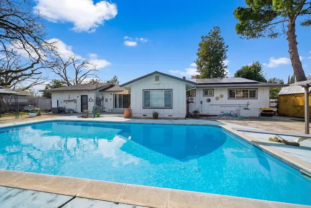 a view of a house with swimming pool and sitting area