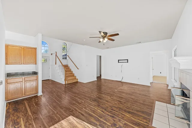 a view of an empty room with a window and wooden floor