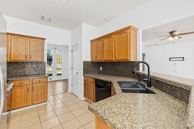 a kitchen with stainless steel appliances granite countertop a stove a sink and a microwave