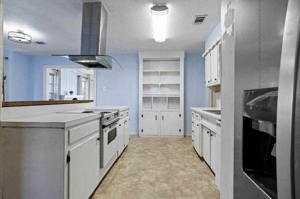 1129 North Riverside Drive Fort Worth, TX 76111 - Photo 11 of 29 a kitchen with cabinets and a stove