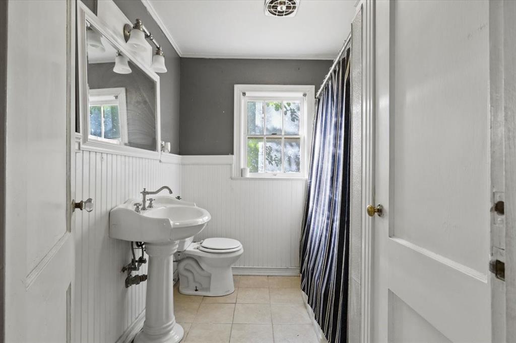 1129 North Riverside Drive Fort Worth, TX 76111 - Photo 18 of 29 a bathroom with a sink toilet and shower