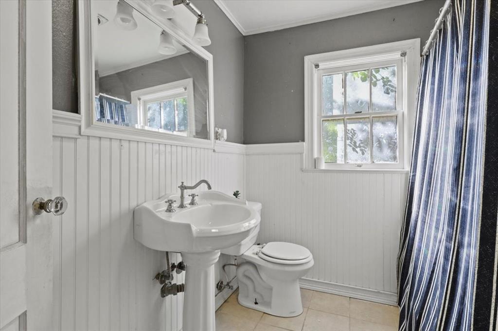 1129 North Riverside Drive Fort Worth, TX 76111 - Photo 19 of 29 a bathroom with a sink toilet and a window