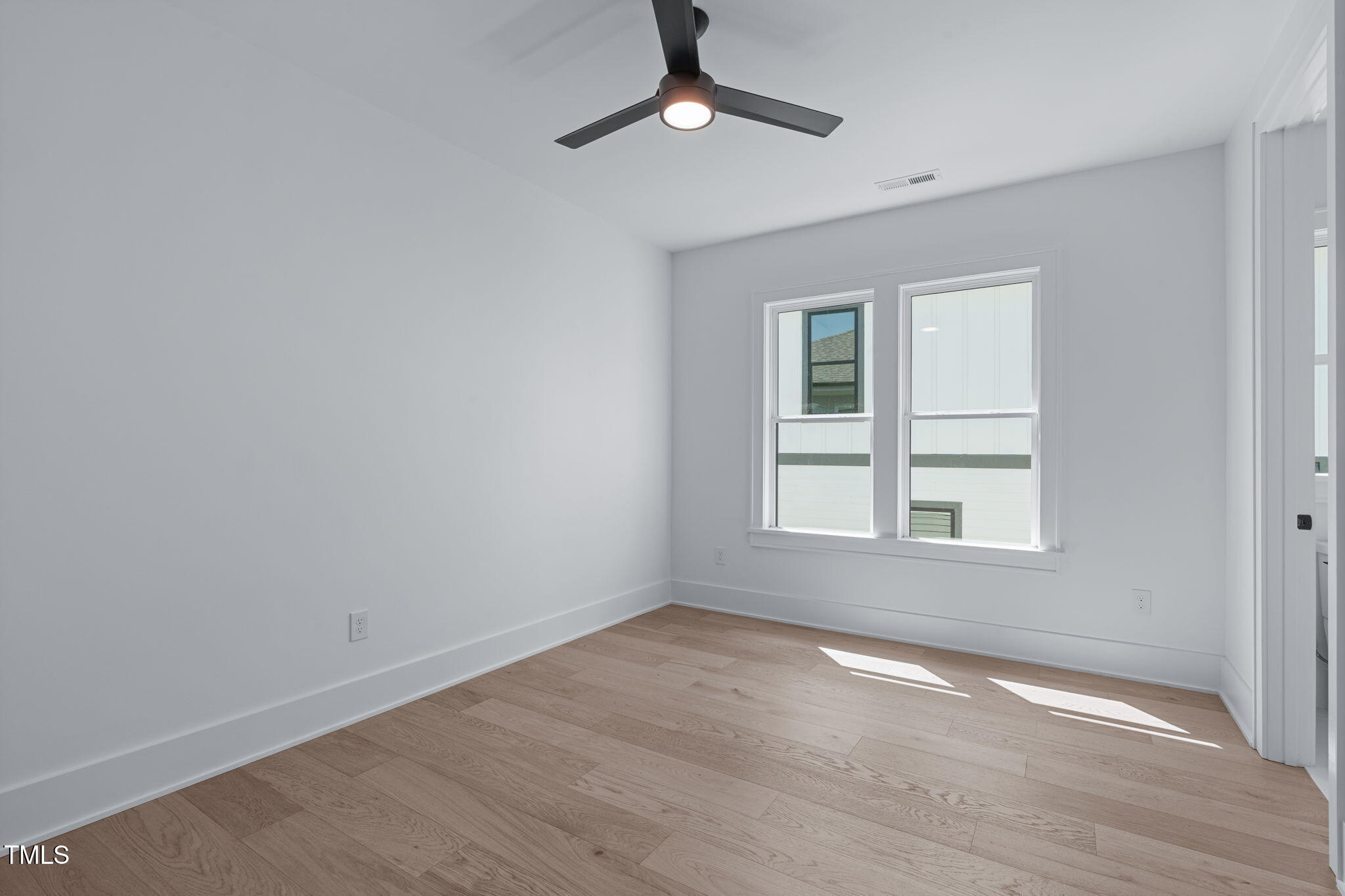 1016 Addison Place Raleigh, NC 27610 - Photo 26 of 50 an empty room with wooden floor chandelier fan and windows