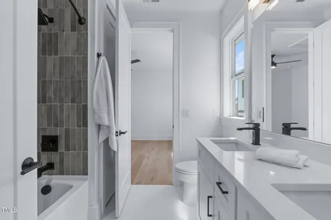 a bathroom with a tub sink toilet and a mirror