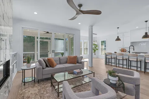 a living room with furniture a fireplace and a floor to ceiling window