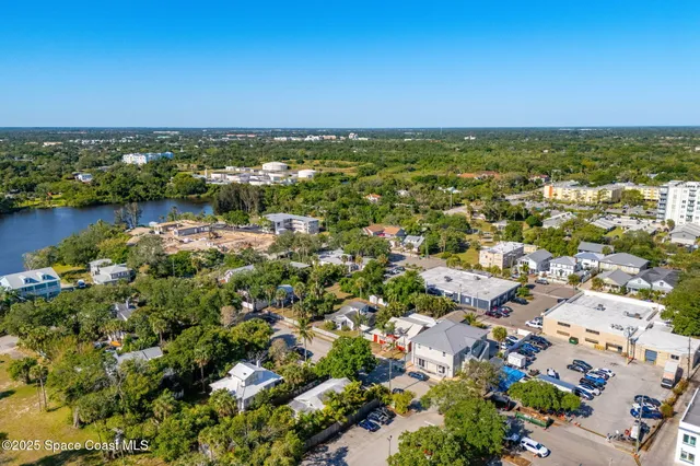 an aerial view of a house with a yard and lake view