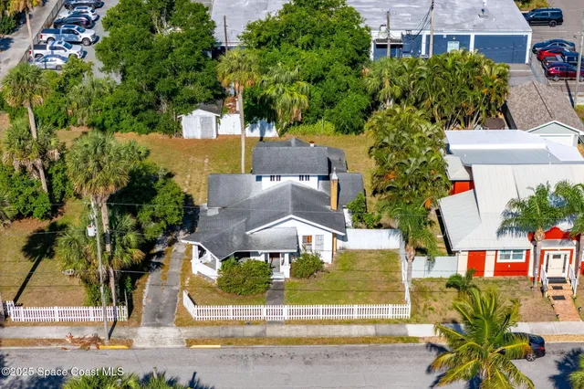 a view of a house with a yard and large trees