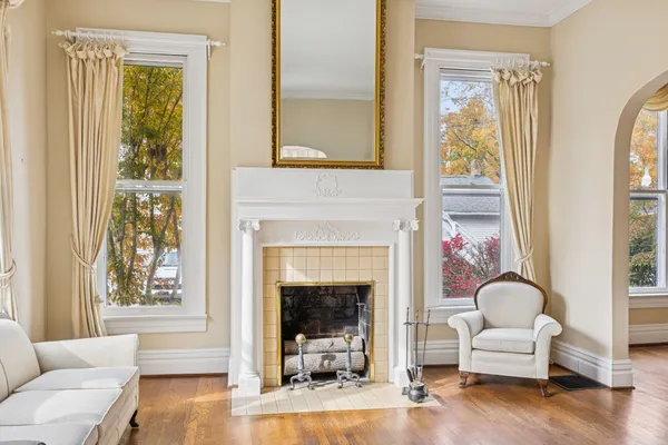 a living room with couches and a dining table with wooden floor