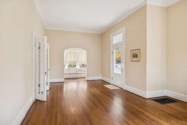 a view of empty room with wooden floor and windows