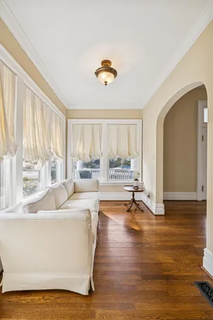 a view of an empty room with wooden floor and kitchen