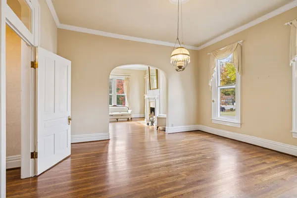 a view of a livingroom with a fireplace a ceiling fan and wooden floor