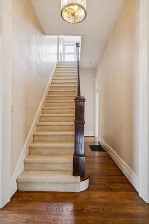 an empty room with wooden floor closet and windows