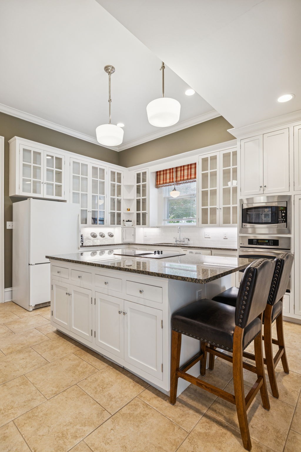 215 4th Avenue South Franklin, TN 37064 - Photo 46 of 86 a kitchen with granite countertop wooden cabinets a stove a sink and a window