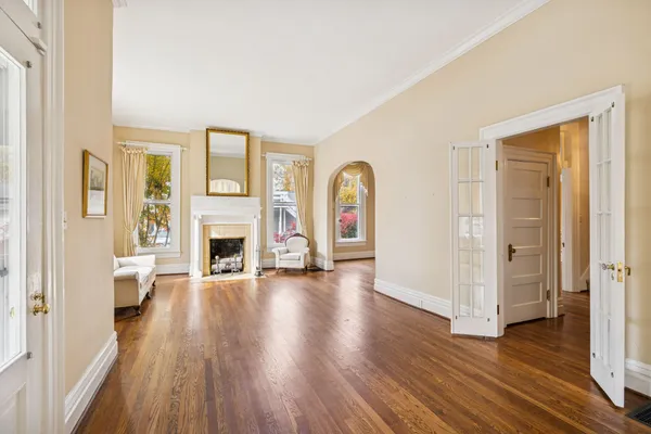 a view of a hallway with wooden floor and a living room