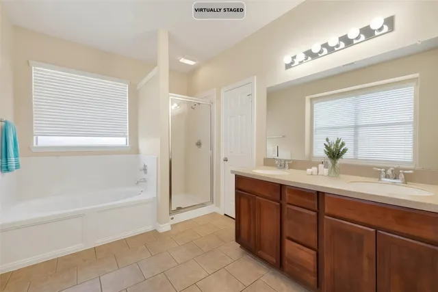 a bathroom with a tub sink shower and two mirror