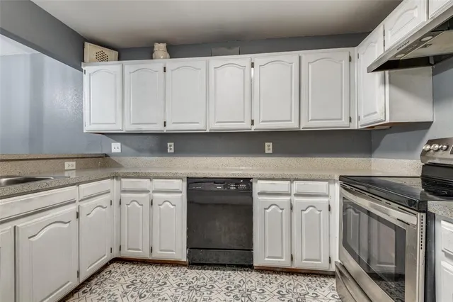 a kitchen with white cabinets and a stove