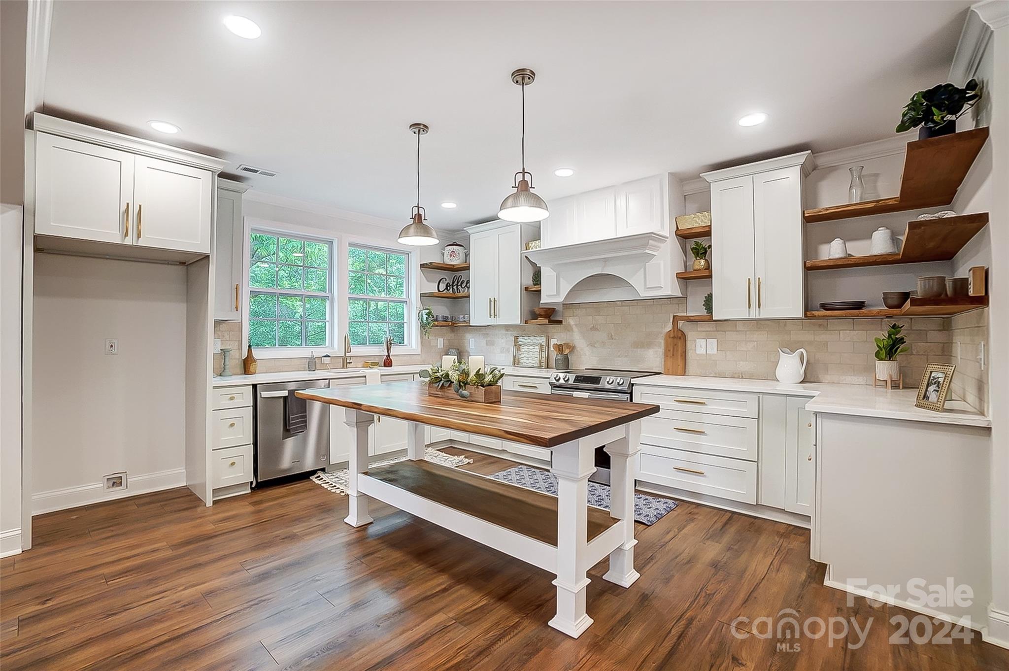 1129 Duckwood Road Lancaster, SC 29720 - Photo 18 of 48 a kitchen with stainless steel appliances a stove a sink dishwasher a refrigerator and white cabinets with wooden floor
