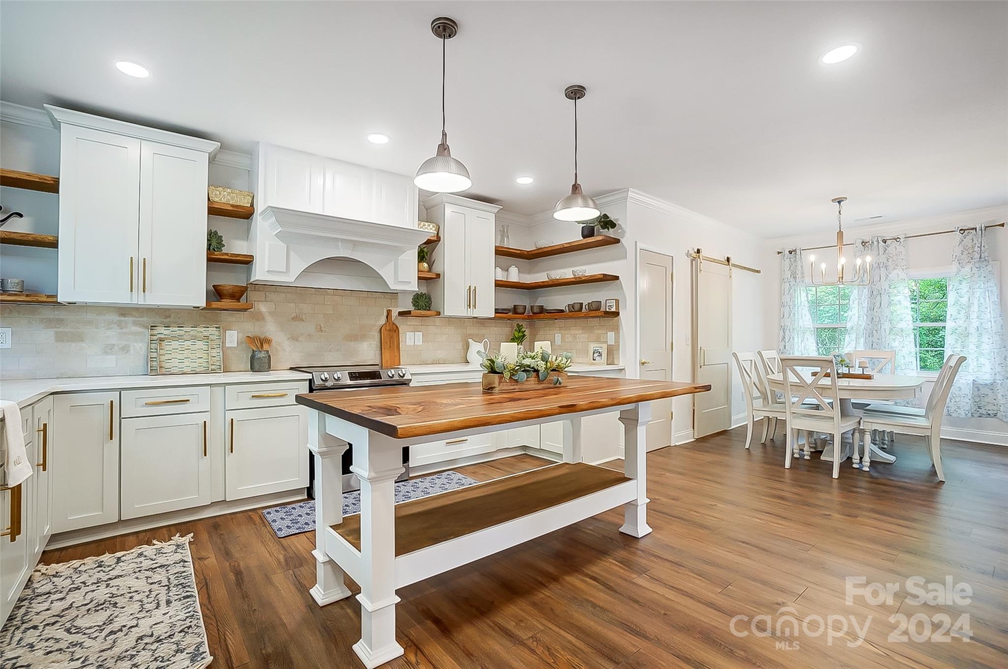 1129 Duckwood Road Lancaster, SC 29720 - Photo 19 of 48 a kitchen with stainless steel appliances granite countertop a stove a sink dishwasher and a dining table with wooden floor